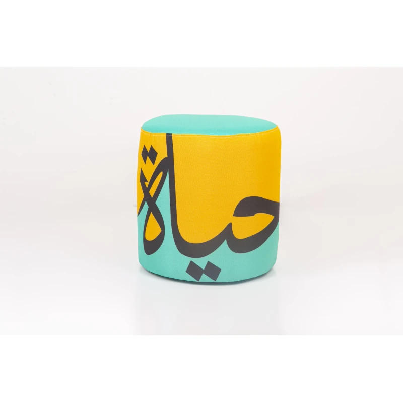 مقعد عثماني مودرن مبطن – تصميم فني بكلمة "حياة" بالخط العربي وألوان زاهية (أصفر وفيروزي) - مؤسسة الحسين للسرطان