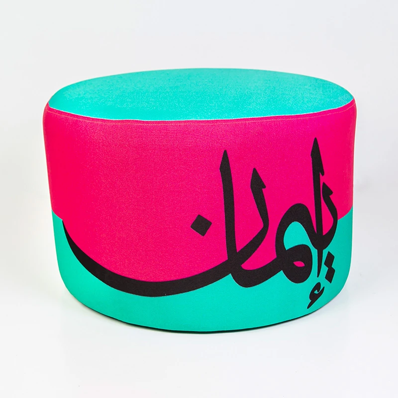 مقعد عثماني مودرن مبطن – تصميم فني بكلمة "إيمان" بالخط العربي وألوان زاهية (وردي وفيروزي) - مؤسسة الحسين للسرطان