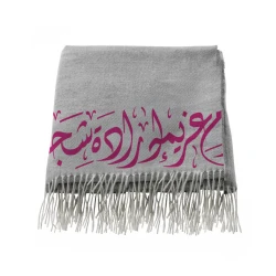 بطانية رمادية ناعمة مزينة بالخط العربي – كلمات "عزيمة، إرادة، شجاعة" باللون الوردي مع أطراف شراشيب أنيقة